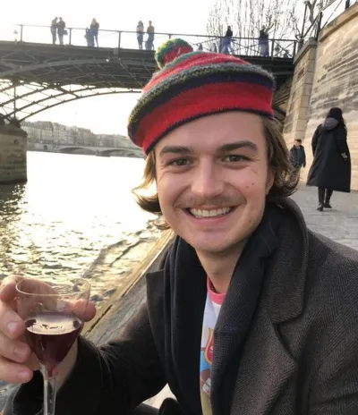 L’image contient peut-être : Stranger Things cast ages, Stranger Things, 3, cast, age, old, birthday, Joe Keery, Steve, Beer Glass, Glass, Beverage, Drink, Alcohol, Beer, Coat, Clothing, Clothing, Person, Human